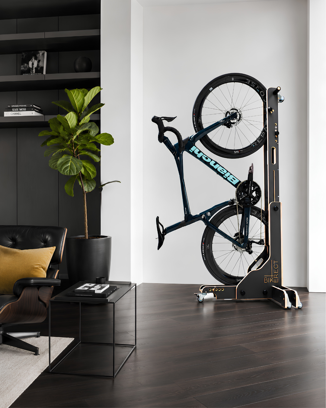 Modré jízdní kolo ve stojanu BIKERECT v moderním interiéru, vedle moderního křesla a květiny.